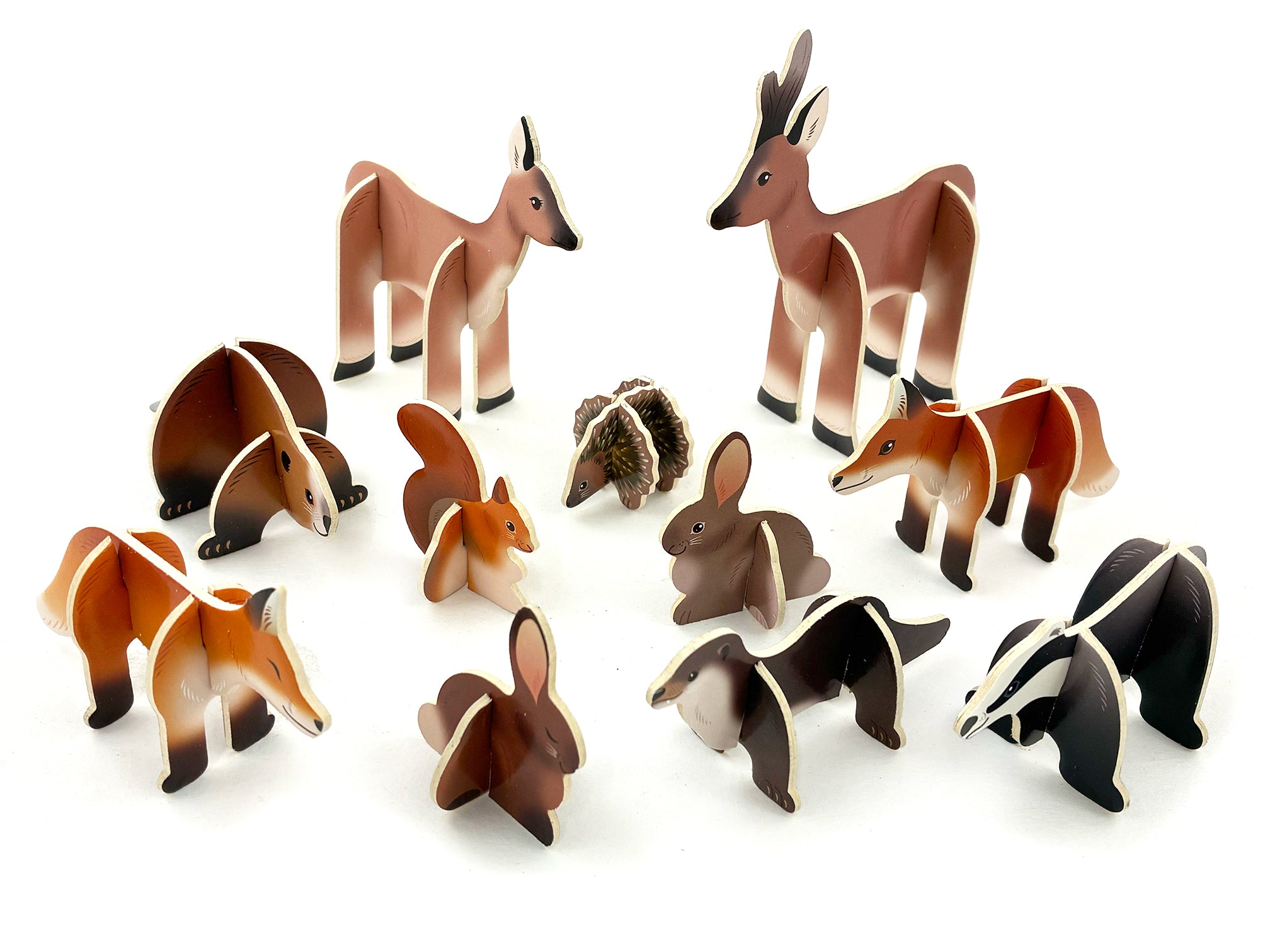 Cardboard woodlands 3D creatures assembled; deers, foxes, hares, squirrel, hedgehog, beaver, otter and badger on white surface.