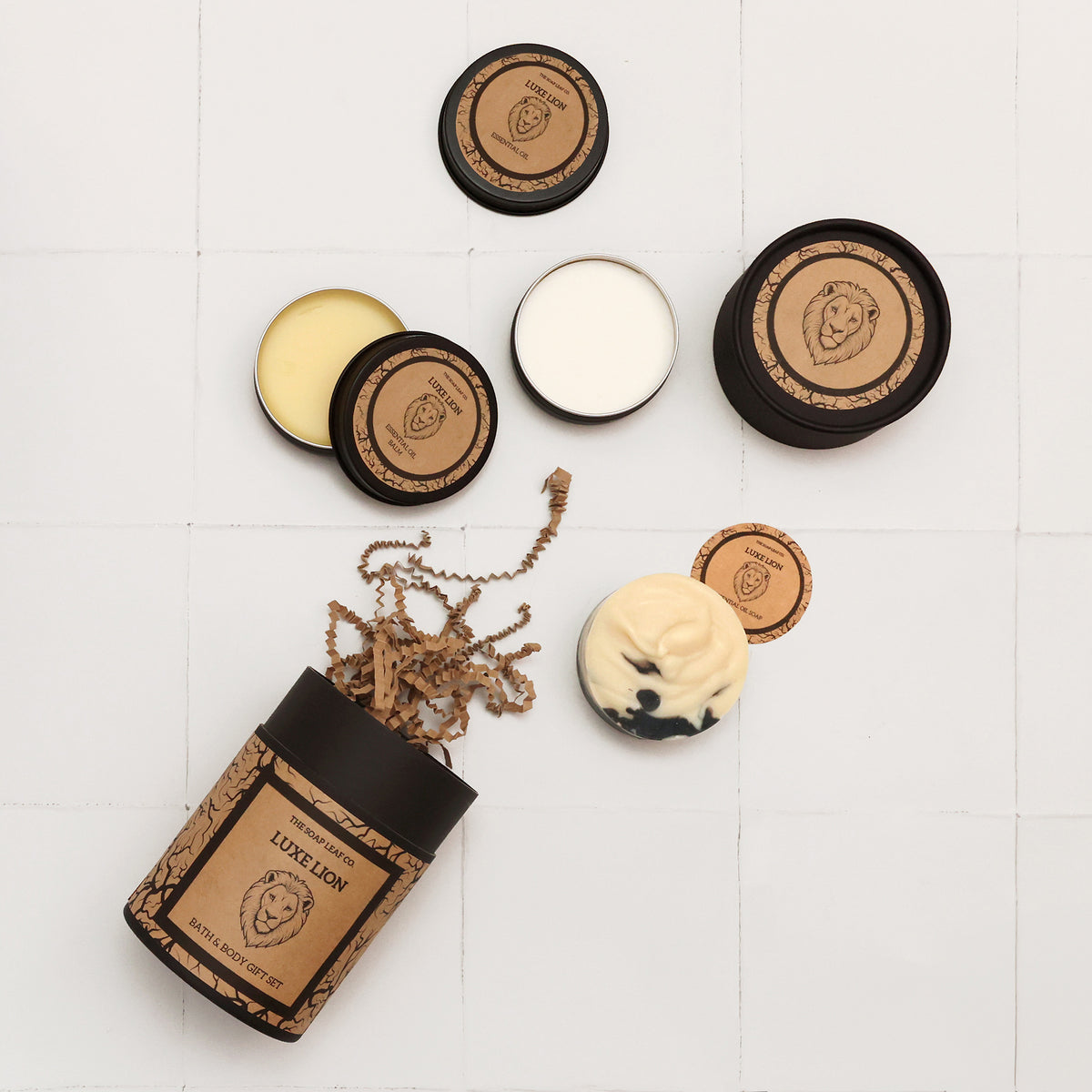 Close up of the contents of the luxe lion gift set with the illustrated lion design on brown craft paper on white tiled surface
