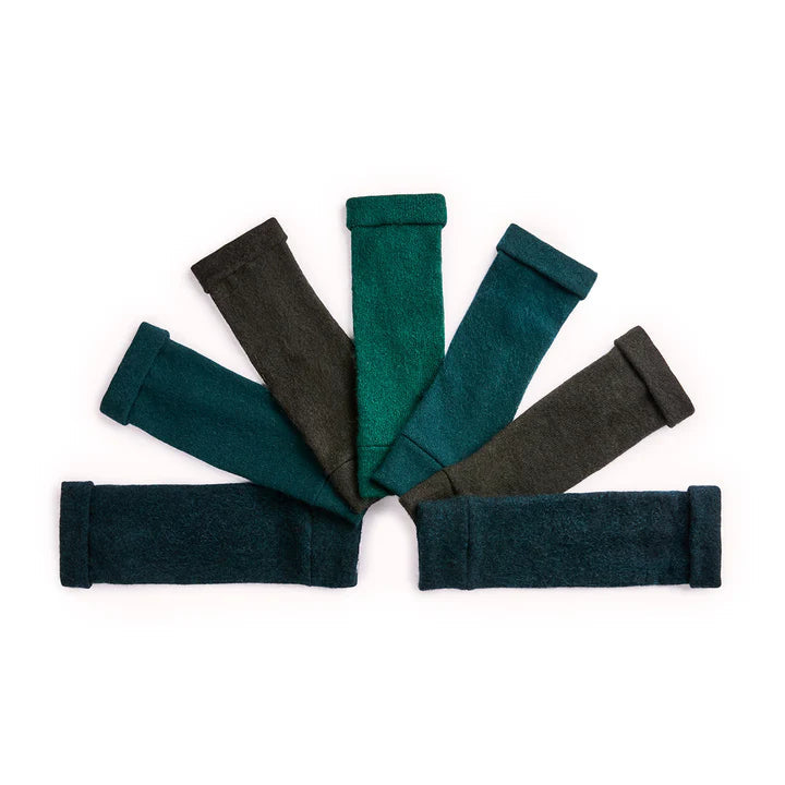Recycled cashmere fingerless gloves in tones of woodlands green on white surface