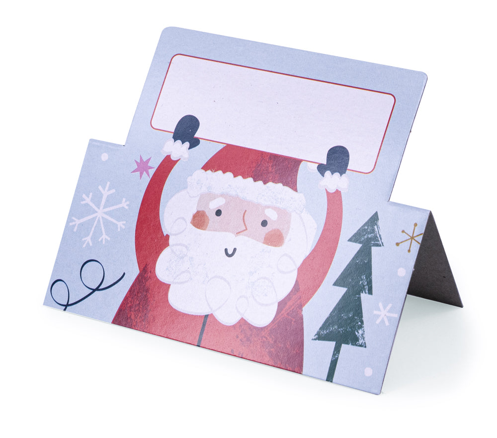 Cardboard place card with illustrated design and santa holding a white box for name folded on white surface