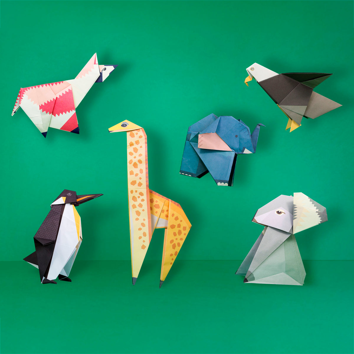 Origami Llama, Eagle, Elephant, Giraffe, Penguin and Koala constructed on green background