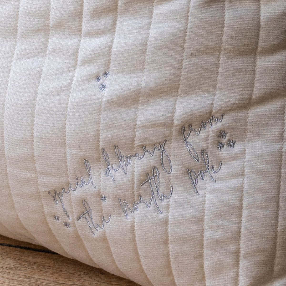 Close up of embroidered messaging "Special delivery from the north pole" in silver written font and stars