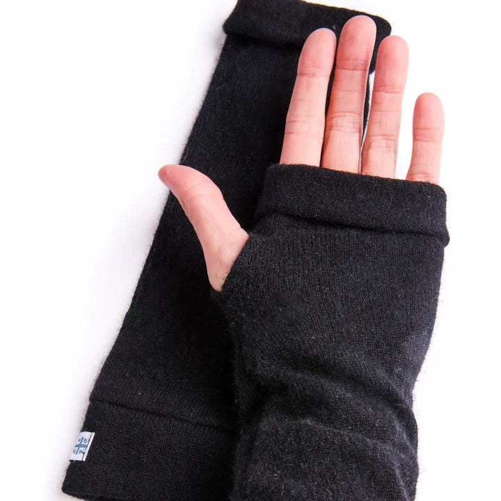 Close up of palm wearing fingerless gloves in black on white surface