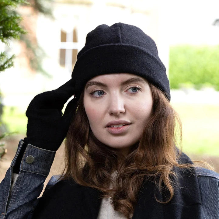 Woman wearing recycled cashmere beanie in black outside