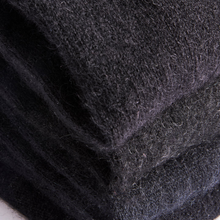 Close up of tones of black recycled cashmere fabric folded