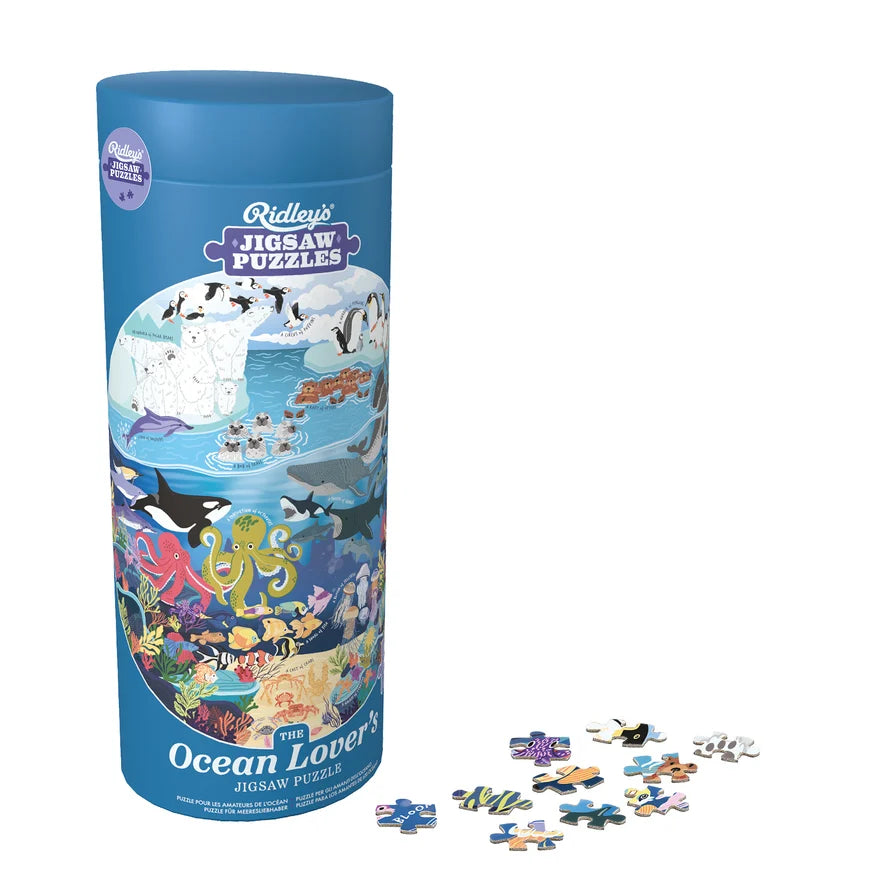 Front of Ocean Lover's Jigsaw Puzzle tube some cardboard puzzle pieces on white surface
