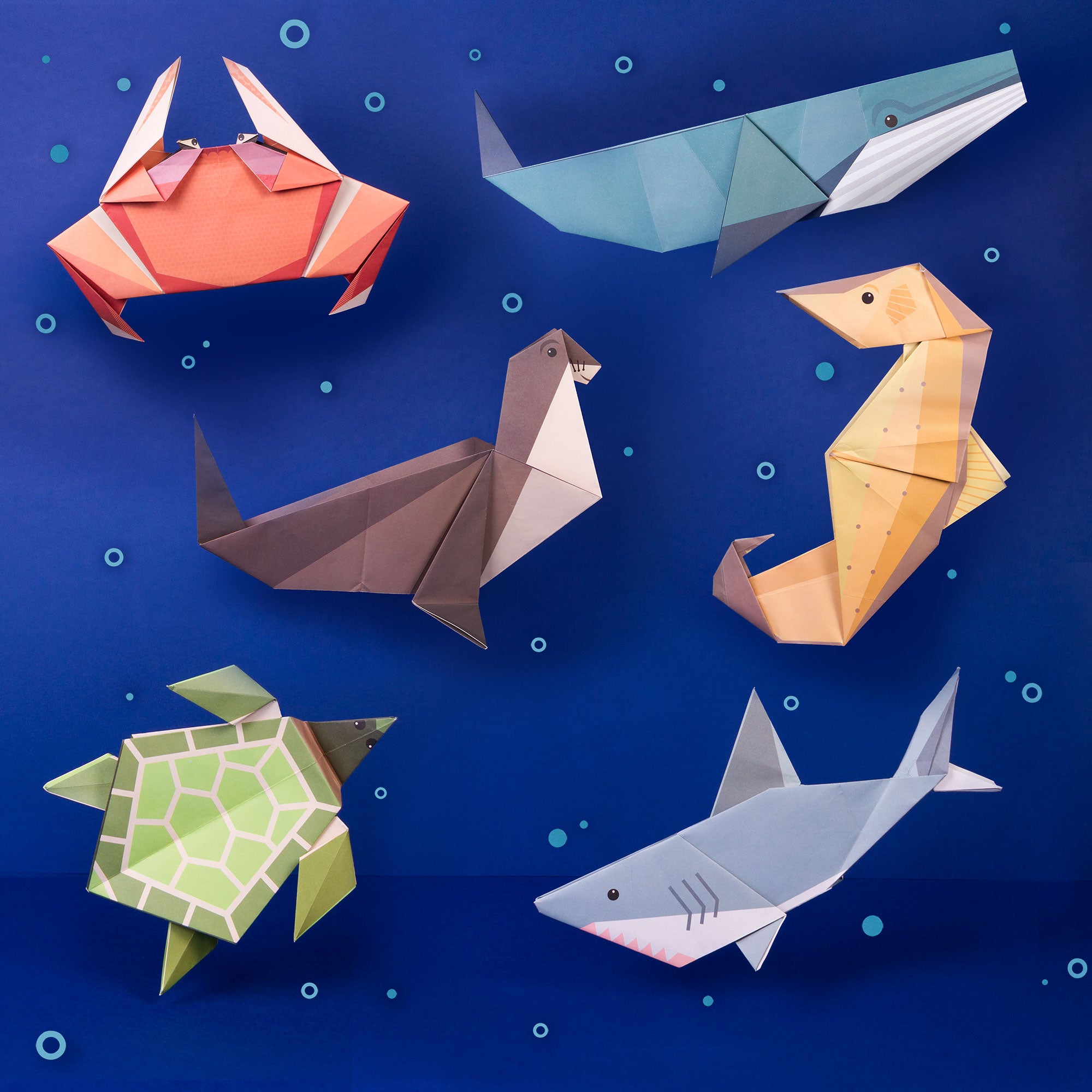 Turtle, Crab, seal, seahorse, whale and shark in origami on blue background with bubbles