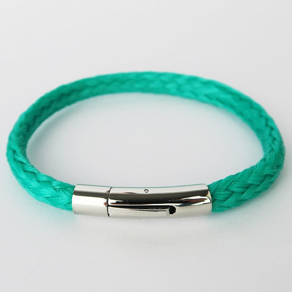 Close up of turquoise recycled fishing net bracelet from above on white surface