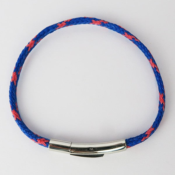 Overhead close up of the red and blue striped bracelet on a white surface
