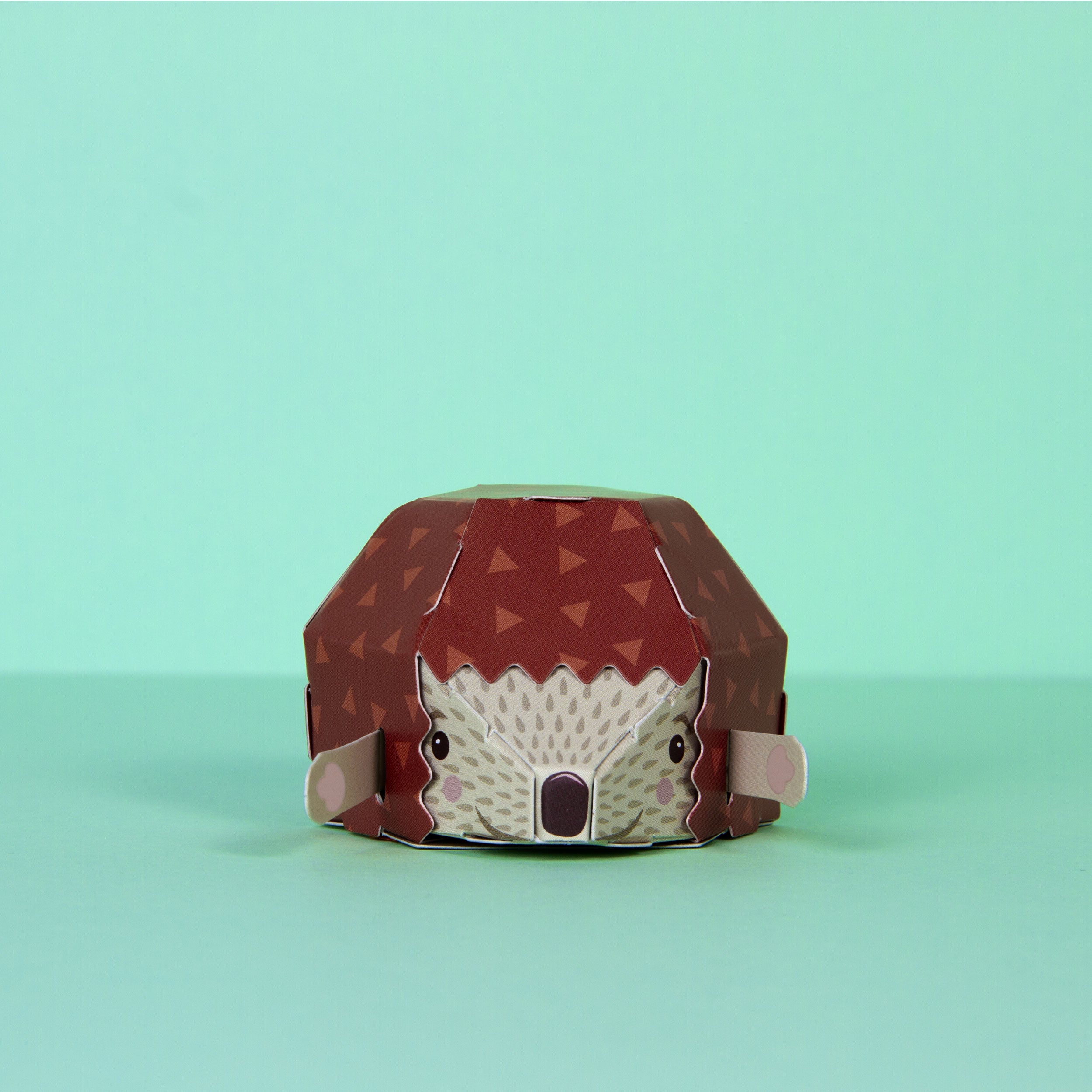 Fully assembled cardboard hedgehog facing forward on mint green background 
