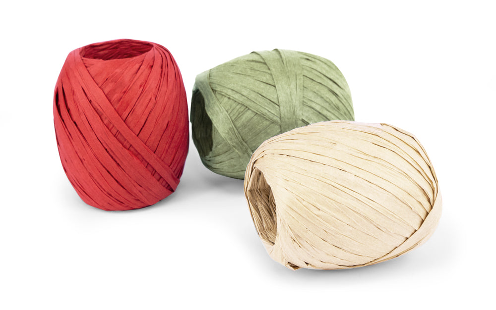 3 reels of paper raffia in green, cream and red on white surface