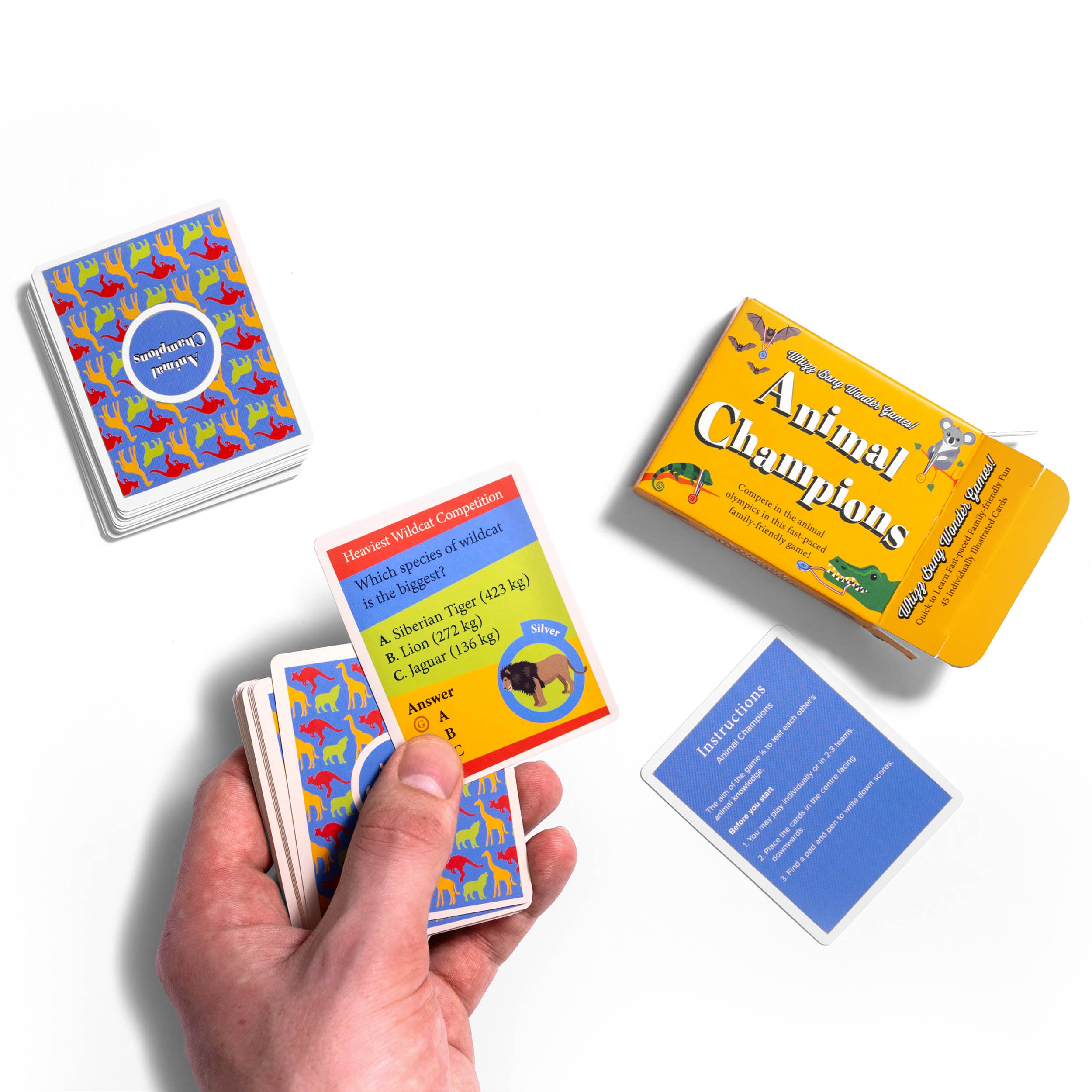 Animal Champions Card Game box with cards laying next to it and hand holding cards on white background