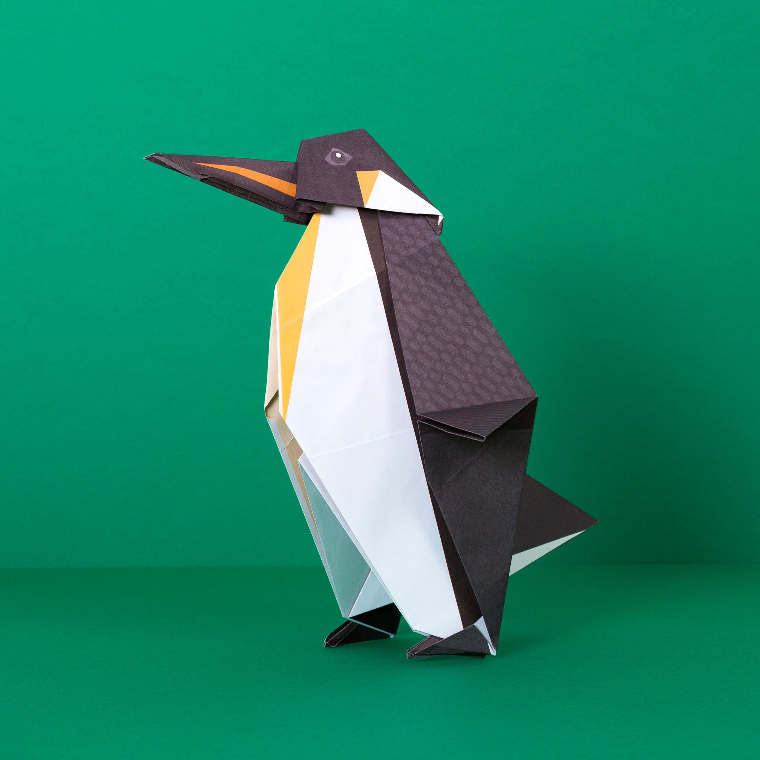 Origami Penguin constructed on green background