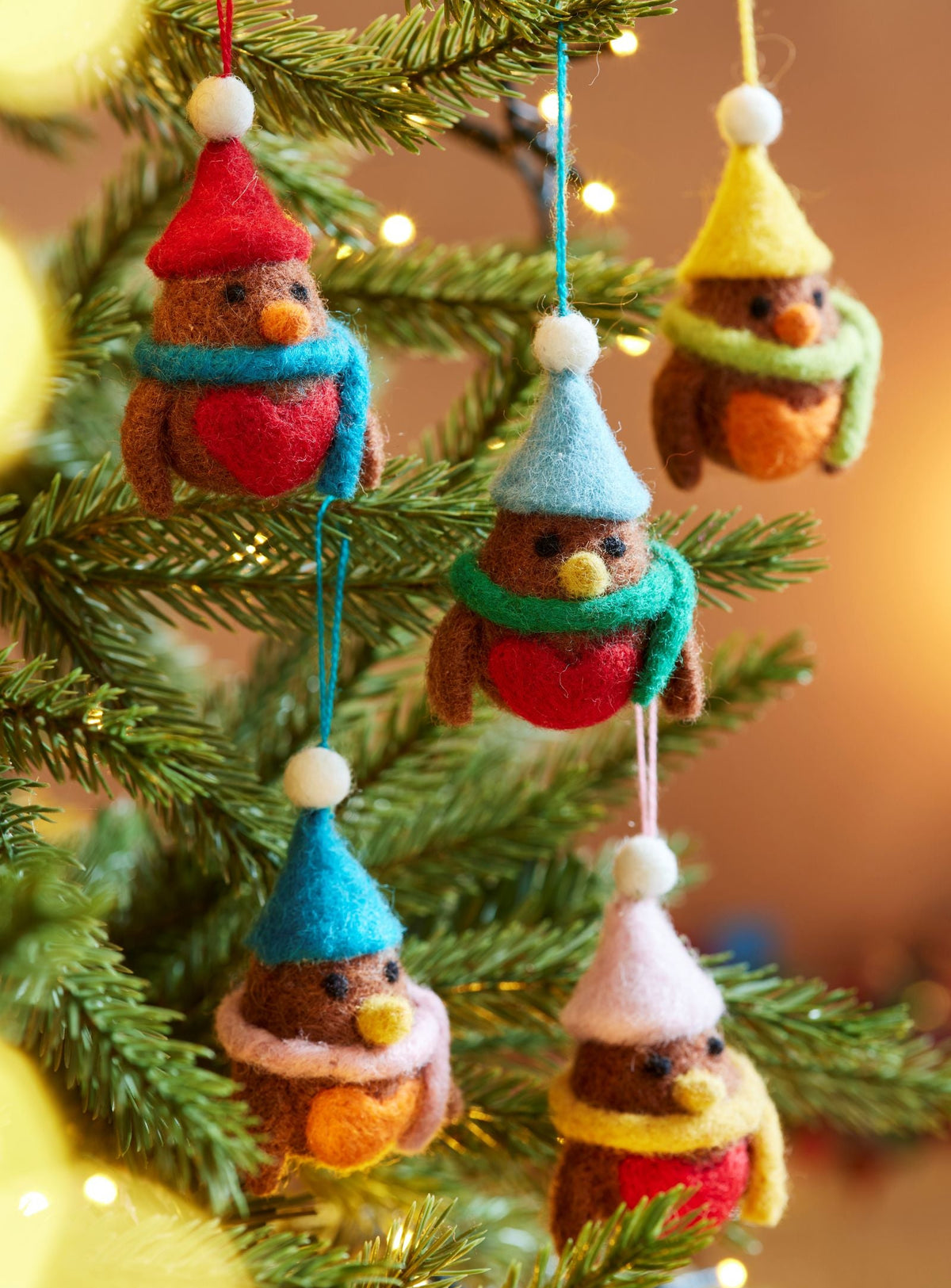 Set of 5 Robin decorations in a mix of colours with bobble hats and scarves made from Felt, hanging in Christmas tree.