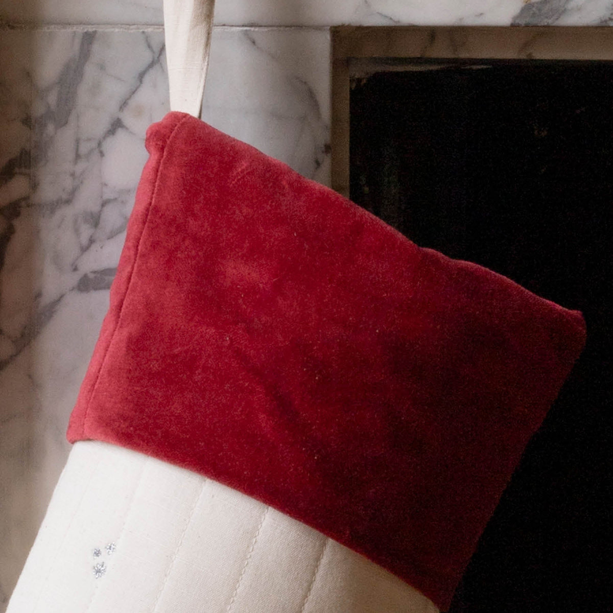 Close up of Red Cotton velvet stocking trim and hanging tie on fire place