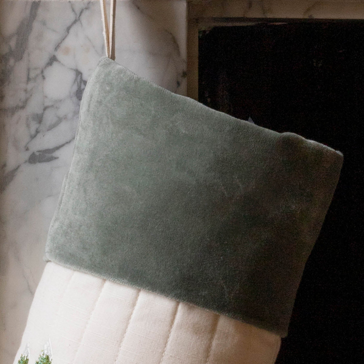 Close up of cotton green velvet trim and hanging tie in front of fireplace