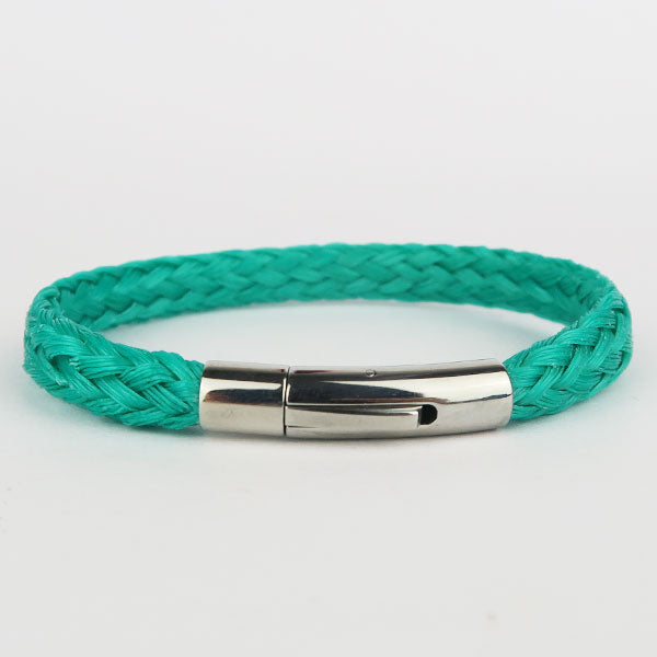 Close up of Turquoise Recycled, chunky, fishing net bracelet with silver clasp on white surface